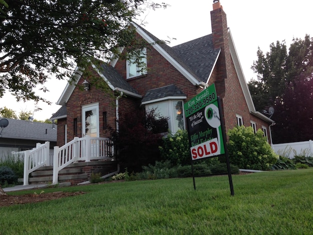 A happy family standing in front of their newly purchased home, with a 