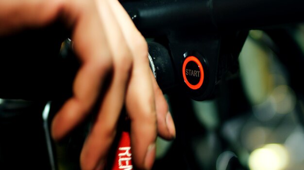 A close-up shot of a hand holding a fuel pump nozzle inserting it into a car's fuel tank. Motion blur effect, indicating the car is being fueled up quickly.