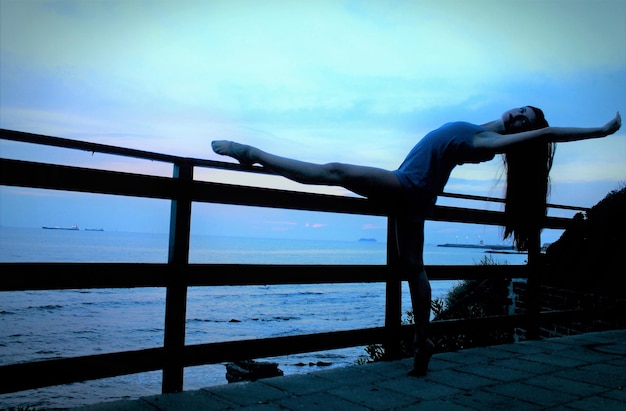 A swimmer stretching by the poolside after a training session, calm expression, professional gear, serene environment, sunset lighting.