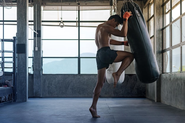 A Brazilian boxer performing plyometric exercises, specifically box jumps, in a modern gym with his trainer observing.