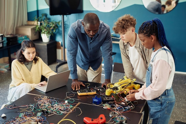 A group of diverse students working collaboratively on a robotics project, showcasing hands-on technical skills.