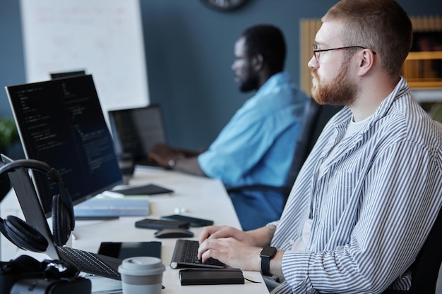 A close-up shot of a person working on a computer, writing code, set in a modern and bright office environment, symbolizing the high demand for IT professionals.