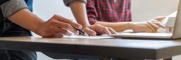 A close-up photo of a student's hands filling out an application form for a scholarship with a pen, with the words 