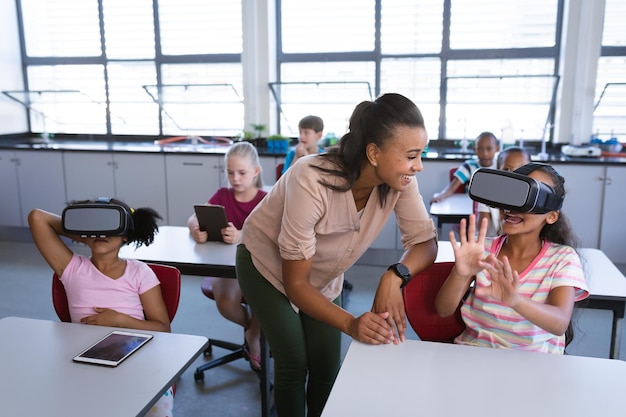 A teacher using a VR headset to teach a lesson, with students around her watching attentively.