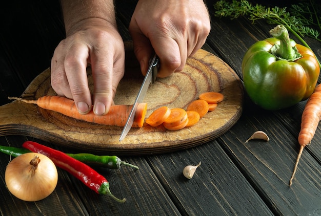 A close-up shot of a chef's hand skillfully using a chef's knife to dice vegetables on a wooden cutting board, with a focus on the knife's sharp blade and the precision of the cut.