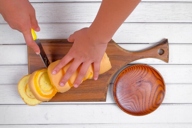 Hands thoroughly cleaning a wooden cutting board with soap and water in a kitchen sink, showcasing proper hygiene practices.